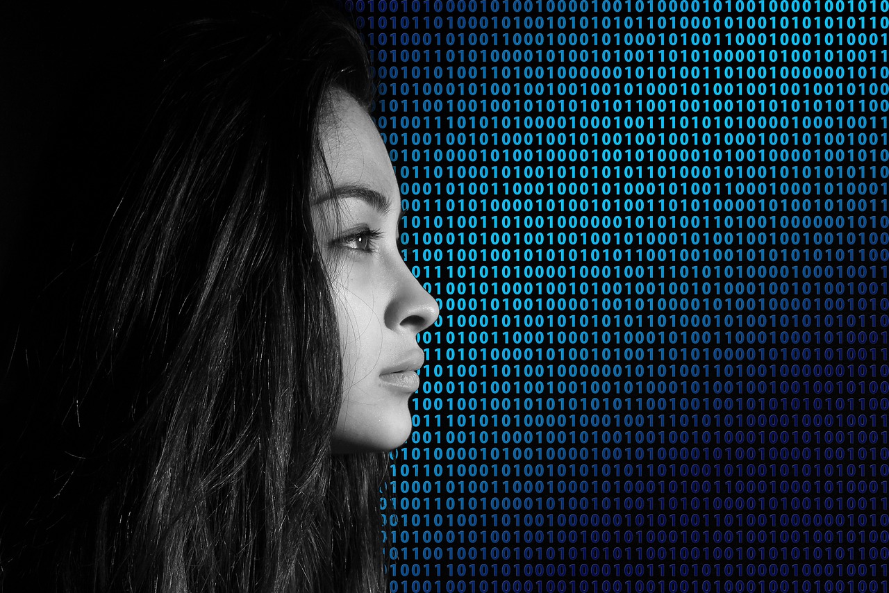 Young woman looking forward, with a background of binary code behind her.